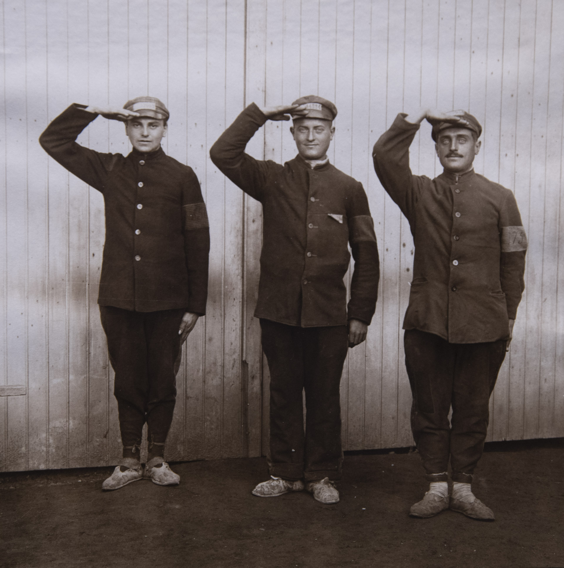Trois prisonniers italiens devant la porte du bâtiment dans lequel ils étaient logés.